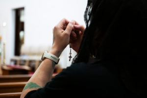 A woman prays after the Eucharistic Procession through downtown LA’s Skid Row, which began and ended at St. Francis Xavier Japanese Catholic Center in Los Angeles on Saturday, July 27. (Victor Alemán)