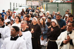 More than 300 priests, seminarians, and lay Catholics kneel in front of the Blessed Sacrament during a Eucharistic Procession through downtown LA’s Skid Row on Saturday, July 27. (Victor Alemán)