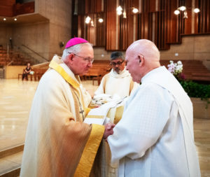 Archbishop José H. Gomez hands over a blessed anniversary stole for deacons celebrating milestones during a special Diaconate Mass at the Cathedral of Our Lady of the Angels on Aug. 10 to celebrate the feast day of St. Lawrence, the notable third-century deacon and martyr. (Victor Alemán)