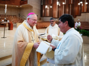 Archbishop José H. Gomez hands over a blessed anniversary stole for deacons celebrating milestones during a special Diaconate Mass at the Cathedral of Our Lady of the Angels on Aug. 10 to celebrate the feast day of St. Lawrence, the notable third-century deacon and martyr. (Victor Alemán)