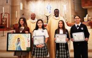 Students were honored for their artwork and essays during the annual Missionary Childhood Association Youth Appreciation Mass: (From left) Anna Louise Ralbovsky of All Souls World Language Catholic School in Alhambra, Illeana Renteria and Kaia Gemette, both of St. Francis Xavier School in Burbank, and Catalina Lozano of Our Lady of the Assumption School in Claremont. (Victor Alemán)