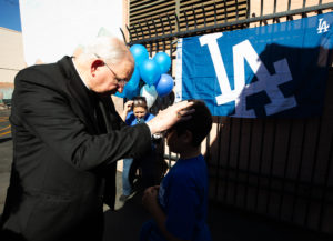 Archbishop José H. Gomez blesses students during an event at Incarnation School in Glendale on Nov. 8 to celebrate funds raised for Catholic Education Foundation of Los Angeles thanks to the Dodgers winning the World Series.(Victor Alemán)