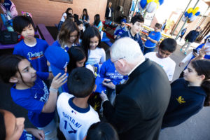 Archbishop José H. Gomez signs Dodgers hats and shirts during an event at Incarnation School in Glendale on Nov. 8 to celebrate funds raised for Catholic Education Foundation of Los Angeles thanks to the Dodgers winning the World Series.(Victor Alemán)