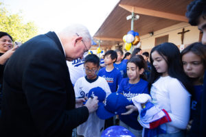 Archbishop José H. Gomez signs Dodgers hats and shirts during an event at Incarnation School in Glendale on Nov. 8 to celebrate funds raised for Catholic Education Foundation of Los Angeles thanks to the Dodgers winning the World Series.(Victor Alemán)