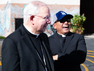 Los Angeles Archbishop José H. Gomez, left, laughs along with Father Rodel Balagtas, pastor at Incarnation Church, during an event at Incarnation School in Glendale on Nov. 8 to celebrate funds raised for Catholic Education Foundation of Los Angeles thanks to the Dodgers winning the World Series. (Victor Alemán)