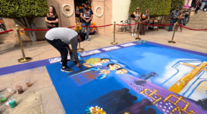 Artist Martin Tenorio Villagomez creates a large-scale sawdust carpet during a Día de los Muertos event at Calvary Cemetery in East LA on Oct. 26. (Maria Hurtado)