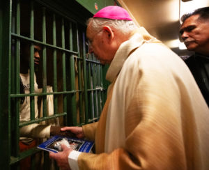 Archbishop José H. Gomez hands copies of 