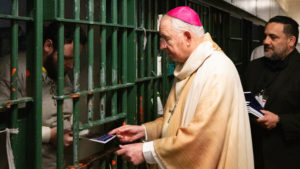 Archbishop José H. Gomez hands copies of 