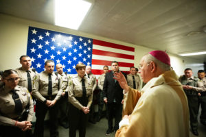 Archbishop José H. Gomez blesses LA County Sheriff Robert Luna and other sheriff's deputies at LA Men's Central Jail during his annual visit and Mass on Christmas Day. (Victor Alemán)