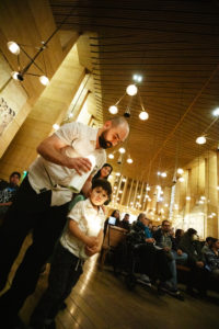 A man and a young boy bring up candles symbolizing a baby killed by abortion during the annual Requiem Mass for the Unborn, the conclusion to the OneLife LA celebration at the Cathedral of Our Lady of the Angels on Jan. 18. (Victor Alemán)