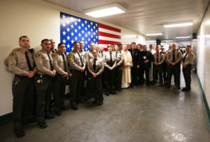 Archbishop José H. Gomez poses with LA County Sheriff Robert Luna and other sheriff's deputies at LA Men's Central Jail during his annual visit and Mass on Christmas Day. (Victor Alemán)