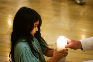 A young girl brings up a candle symbolizing a baby killed by abortion during the annual Requiem Mass for the Unborn, the conclusion to the OneLife LA celebration at the Cathedral of Our Lady of the Angels on Jan. 18. (Victor Alemán)