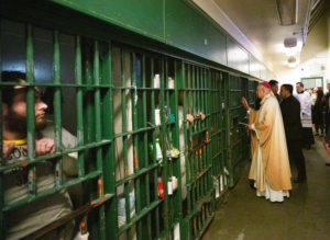 Archbishop José H. Gomez shakes hands and blesses inmates at LA Men's Central Jail during his annual visit on Christmas Day. (Victor Alemán)