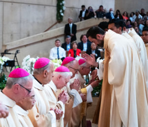 The eight new priests bless the bishops in attendance for the ordination Mass at the Cathedral of Our Lady of the Angels on May 31.(Victor Alemán)