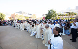Attendees kneel during a Eucharistic procession in the outdoor plaza at the Cathedral of Our Lady of the Angels on June 22 during the National Eucharistic Pilgrimage. ((Victor Alemán)