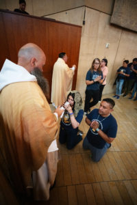 A couple kneels to receive holy Communion at the Cathedral of Our Lady of the Angels on June 22 for Mass during the National Eucharistic Pilgrimage. (Victor Alemán)