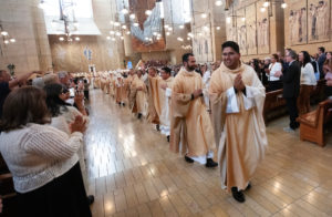 The eight newly ordained priests receive applause processing out following the ordination Mass at the Cathedral of Our Lady of the Angels on May 31. (Victor Alemán)