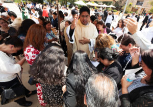 Father Jorge Moncada blesses a group of loved ones and supporters following the ordination Mass at the Cathedral of Our Lady of the Angels on May 31. (Victor Alemán)