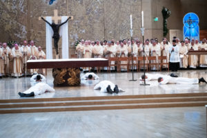 The eight men prostrate themselves at the altar during the ordination Mass at the Cathedral of Our Lady of the Angels on May 31. (Victor Alemán)