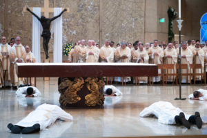 The eight men prostrate themselves at the altar during the ordination Mass at the Cathedral of Our Lady of the Angels on May 31. (Victor Alemán)