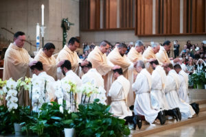 The eight men receive laying of hands from priests during the ordination Mass at the Cathedral of Our Lady of the Angels on May 31. (Victor Alemán)