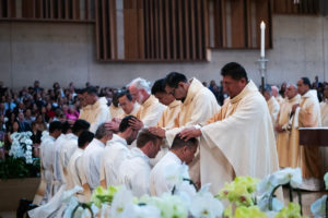 The eight men receive laying of hands from priests during the ordination Mass at the Cathedral of Our Lady of the Angels on May 31. (Victor Alemán)