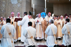 The eight men receive prayers during the ordination Mass at the Cathedral of Our Lady of the Angels on May 31. (Victor Alemán)