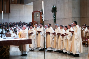 The eight new priests participate in the consecration with Archbishop José H. Gomez during the ordination Mass at the Cathedral of Our Lady of the Angels on May 31.(Victor Alemán)