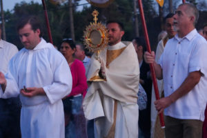 Father Parker Sandoval carries the monstrance during a Eucharistic procession as part of the National Eucharistic Pilgrimage that traveled through the streets of Altadena that were burned in the Eaton Fire on June 20. (Katie Trejo)