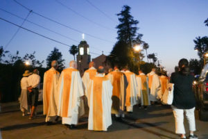 The lit-up cross atop Sacred Heart Church in Altadena beckons the Eucharistic procession that traveled on June 20 as part of the National Eucharistic Pilgrimage through neighborhoods burned during the Eaton Fire. (Katie Trejo)