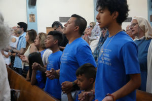 A family wearing matching shirts attends Mass at Mission San Gabriel Arcángel on June 21 as part of the National Eucharistic Pilgrimage. (Katie Trejo)