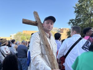 John David Rutledge proudly displays a cross buried in weeds that he found as part of the Camino de California pilgrimage that merged with the National Eucharistic Pilgrimage. (Natalie Romano)