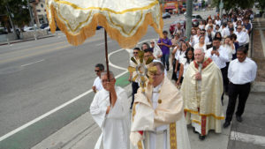 Father Gary Mueller, CM, pastor at St. Vincent DePaul Church in Los Angeles, with Auxiliary Bishop Matthew Elshoff close behind, carries the monstrance holding the Blessed Sacrament during Day 2 of the National Eucharistic Pilgrimage’s appearance in LA on June 21. (Katie Trejo)