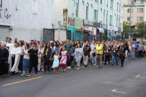 Hundreds follow behind the Blessed Sacrament during a Eucharistic procession through Skid Row in downtown Los Angeles on July 19. (Alex Salcedo)