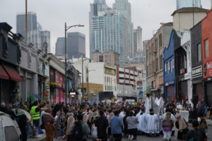 Hundreds kneel in front of the Blessed Sacrament during a Eucharistic procession through Skid Row in downtown Los Angeles on July 19, helped put on by the Archdiocese of Los Angeles’ Office for Vocations. (Alex Salcedo)