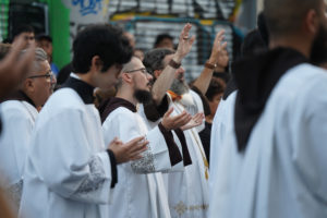 Priests, seminarians and lay people pray during a stop for adoration with the Blessed Sacrament during a Eucharistic procession through Skid Row in downtown Los Angeles on July 19. (Alex Salcedo)
