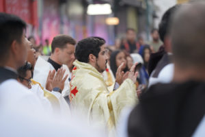 Father Emmanuel Sanchez prays during a stop for adoration with the Blessed Sacrament during a Eucharistic procession through Skid Row in downtown Los Angeles on July 19. (Alex Salcedo)