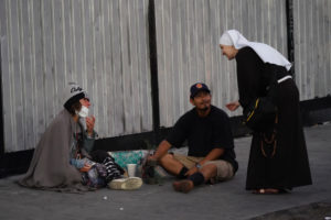 A member of the Sisters Poor of Jesus Christ reaches out to those in need during a Eucharistic procession through Skid Row in downtown Los Angeles on July 19. (Alex Salcedo)