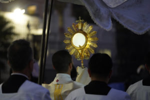 A priest carries the Blessed Sacrament while hundreds follow behind during a Eucharistic procession through Skid Row in downtown Los Angeles on July 19. (Alex Salcedo)