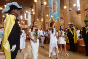 Attendees carry flowers to place in front of the Virgin Mary statue during the “One Mother, Many Peoples” Mass at the Cathedral of Our Lady of the Angels on Sept. 6, which celebrated the diverse cultures, organizations, and ethnic ministries in the Archdiocese of Los Angeles. (Reese Cuevas/Archdiocese of Los Angeles)