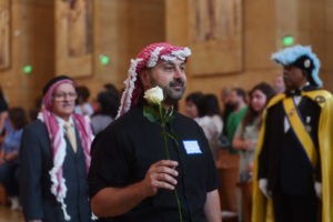 Attendees carry flowers to place in front of the Virgin Mary statue during the “One Mother, Many Peoples” Mass at the Cathedral of Our Lady of the Angels on Sept. 6, which celebrated the diverse cultures, organizations, and ethnic ministries in the Archdiocese of Los Angeles. (Reese Cuevas/Archdiocese of Los Angeles)