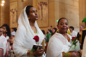 Attendees carry flowers to place in front of the Virgin Mary statue during the “One Mother, Many Peoples” Mass at the Cathedral of Our Lady of the Angels on Sept. 6, which celebrated the diverse cultures, organizations, and ethnic ministries in the Archdiocese of Los Angeles. (Reese Cuevas/Archdiocese of Los Angeles)