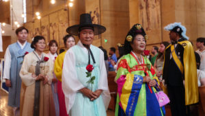 Attendees carry flowers to place in front of the Virgin Mary statue during the “One Mother, Many Peoples” Mass at the Cathedral of Our Lady of the Angels on Sept. 6, which celebrated the diverse cultures, organizations, and ethnic ministries in the Archdiocese of Los Angeles. (Reese Cuevas/Archdiocese of Los Angeles)