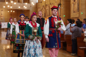 Attendees carry flowers to place in front of the Virgin Mary statue during the “One Mother, Many Peoples” Mass at the Cathedral of Our Lady of the Angels on Sept. 6, which celebrated the diverse cultures, organizations, and ethnic ministries in the Archdiocese of Los Angeles. (Reese Cuevas/Archdiocese of Los Angeles)