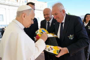 Pope Leo XIV signs a helmet for a representative of the Italian Motorcyclists' Federation after an audience for the Jubilee of Migrants and the Jubilee of the Missions Oct. 4, 2025. (CNS photo/Vatican Media)