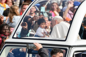 Pope Leo XIV greets a child from the popemobile as he rides around St. Peter’s Square following Mass for the Jubilee of Migrants and the Jubilee of the Missions in St. Peter’s Square at the Vatican Oct. 5, 2025. (CNS photo/Lola Gomez)