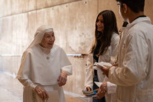 Volunteers hand out programs for the Healthcare Professionals Mass, known as the White Mass, at the Cathedral of Our Lady of the Angels on Oct. 12. (Lizzie Friedrich)