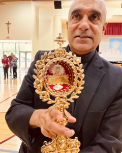 Msgr. Anthony Figueiredo, a priest in Assisi, Italy, displays the relics of St. Carlo Acutis at Bishop Conaty - Our Lady of Loretto High School on Oct. 21 during a tour of the saint's relics. (Bishop Conaty - Our Lady of Loretto High School)
