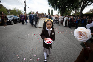 A young student from Saint Therese Carmelite School in Alhambra sprinkles rose petals ahead of the relics of St. Thérèse during a procession to the Sacred Heart Retreat House on Oct. 13 during a U.S. tour of the saint's relics. (Jeffrey Bruno)
