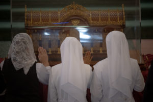 Women religious venerate in front of the St. Thérèse reliquary at the Sacred Heart Retreat House in Alhambra on Oct. 13 during a U.S. tour of the saint's relics. (Jeffrey Bruno)